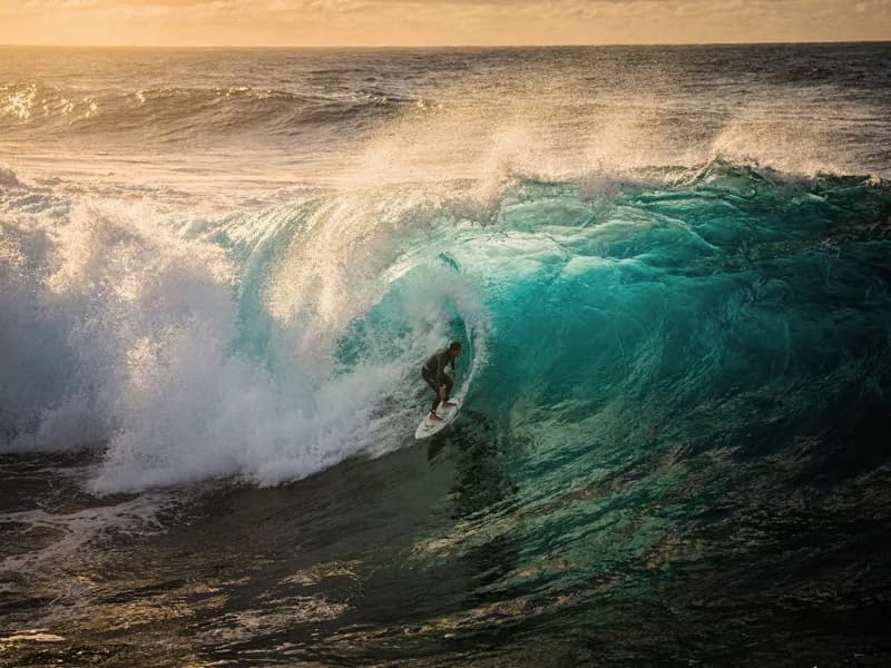 Aerial cinematic shot of a surfer riding a turquoise wave at golden hour, demonstrating Seedance AI camera control capabilities